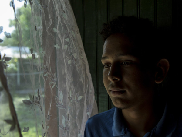 UNICEF/Adriana Zehbrauskas Victor Fernando, 17 ans, se tient près de la fenêtre de son domicile de Villanueva, au Honduras. Il a été victime d'intimidation à l'école concernant son orientation sexuelle. Depuis que l'intimidation a commencé, ses notes ont chuté.
