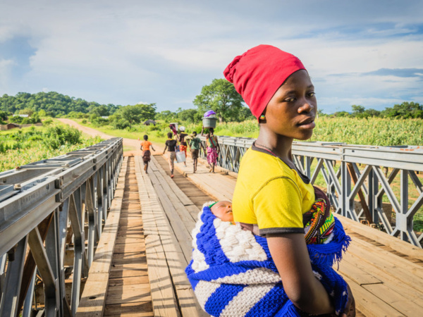 PAM/Badre Bahaji Au Malawi, une femme et son nourrisson traverse un pont pour se rendre au centre de santé Lugola à Chikulo. le pont a été construit grâce à un financement du Programme alimentaire mondial des Nations Unies (PAM) PAM/Badre Bahaji Au Malawi, une femme et son nourrisson traverse un pont pour se rendre au centre de santé Lugola à Chikulo. le pont a été construit grâce à un financement du Programme alimentaire mondial des Nations Unies (PAM)