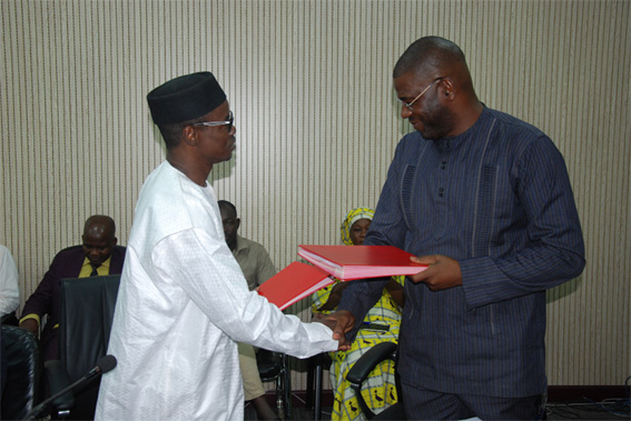 Hamed Salif Camara de l’AGETIC et Mahamadou Wadidié de l’ADR échangent les documents de l’accord Hamed Salif Camara de l’AGETIC et Mahamadou Wadidié de l’ADR échangent les documents de l’accord