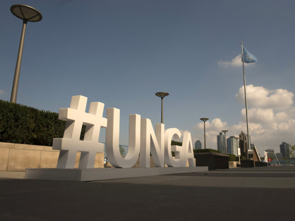 Photo ONU/Kim Haughton Devant le siège de l'ONU à New York, l’Assemblée générale des Nations Unies fait la promotion de son débat général annuel avec le hashtagh de ses acronymes en anglais (archive)